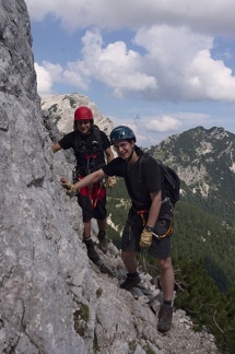 Úzká nejištená římsa, vzadu je Mojstrovka.